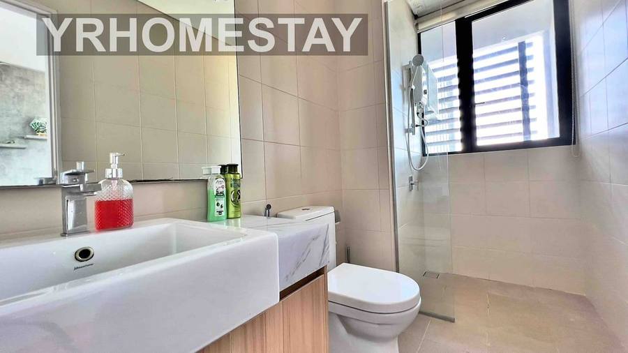 Bathroom with a basin, toilet and a glass-screened shower.