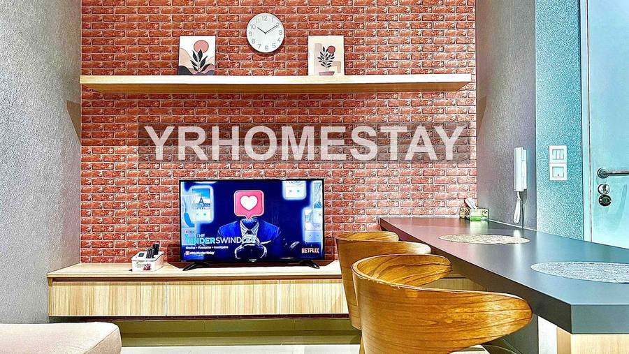 Dining counter with stools facing a wall-mounted television on the brick feature wall.